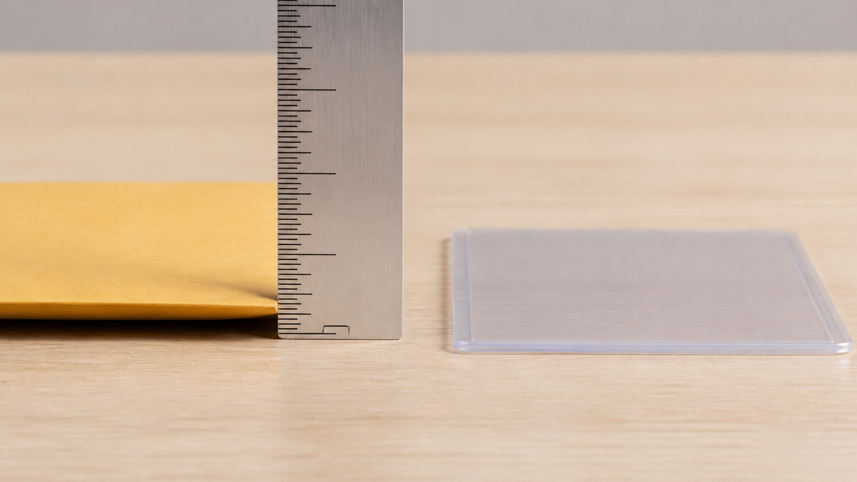 定規で封筒の厚みを測る発送前チェックのクローズアップ